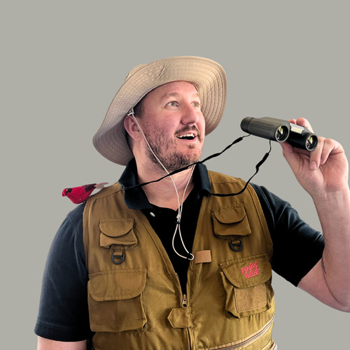 Man birdwatching with binoculars and hat.